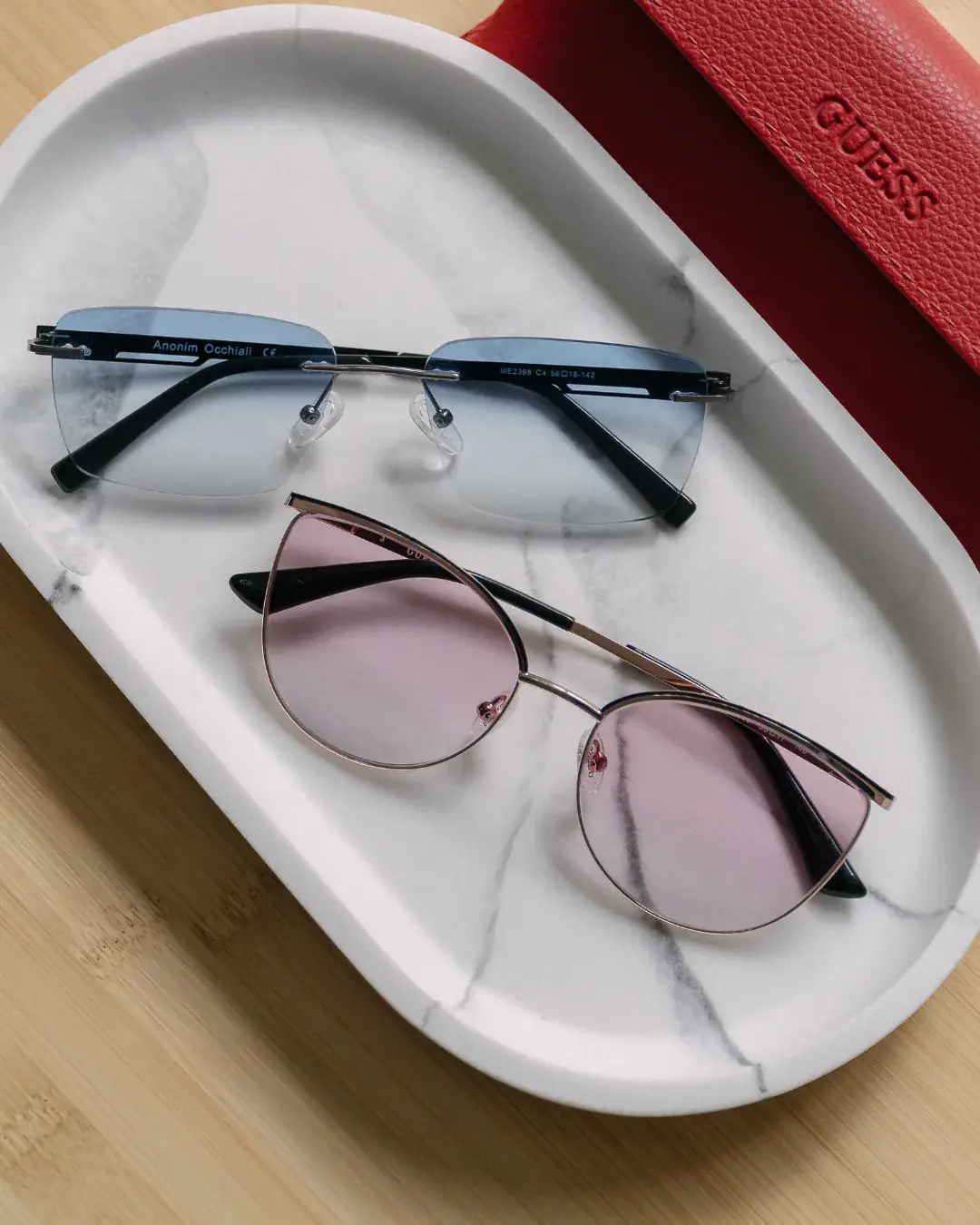 Commercial photo — Guess sunglasses on marble tray
